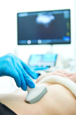 Tıbbi ultrason görüntüleme ve tarama. Klinikteki kadın hastanın midesini inceliyorum. Kanser erken tanı. Fokus 'un sığ derinliği. Doğal koşullarda otantik çekim. Biraz bulanık olabilir.