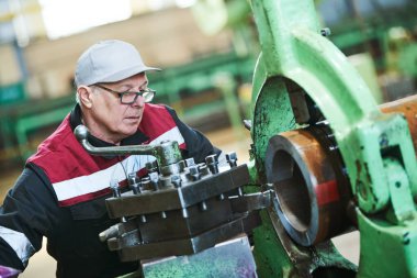 Torna Makinesi üretim fabrikası'nda üzerinde metal mil işleme sanayi işçisi turner