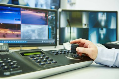 Güvenlik kamerası. Güvenlik görevlisi video izliyor ve izleme sistemi kullanıyor.