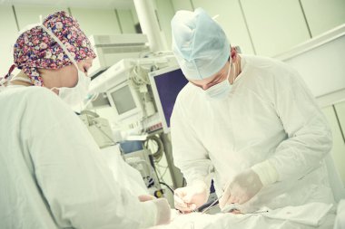 Ameliyat konsepti. Cerrahlar, ameliyat odasında ya da ameliyathanede karın boşluğunda ameliyat yapıyor.