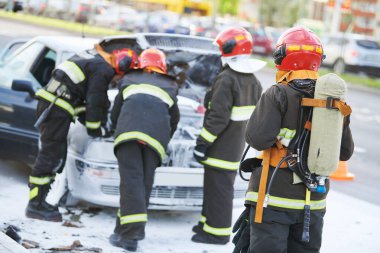 Araba kazasında itfaiyeciler. Şehir sokağındaki yangını yakıp söndürdükten sonra otomobil. Aracın elektrik sisteminde kısa devre