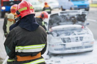 Araba kazasında itfaiyeciler. Şehir sokağındaki yangını yakıp söndürdükten sonra otomobil. Aracın elektrik sisteminde kısa devre