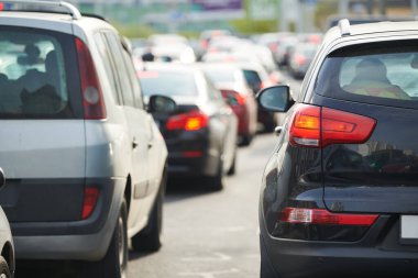Trafik sıkışıklığı ya da trafik sıkışıklığı ve trafik saatlerinde şehir caddesinde sıra sıra giden arabalar..