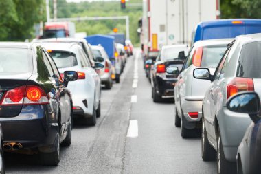 Trafik sıkışıklığı ya da trafik sıkışıklığı ve trafik saatlerinde şehir caddesinde sıra sıra giden arabalar..