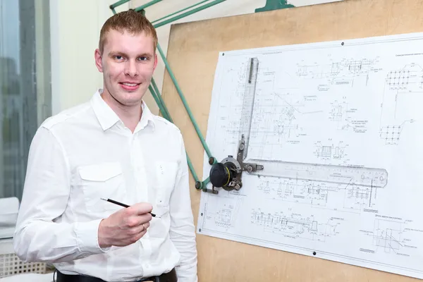 Assistente de engenharia bonito com lápis no local de trabalho perto da placa do painel — Fotografia de Stock