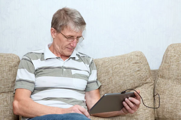 Elderly man connected on internet with electronic tab — Stock Photo, Image