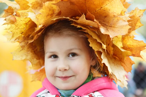 Kind glückliches Gesicht mit gelben maples — Stockfoto