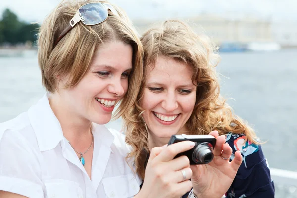 Two happy women looking at screen of simple hand-held camera — Stock Photo, Image