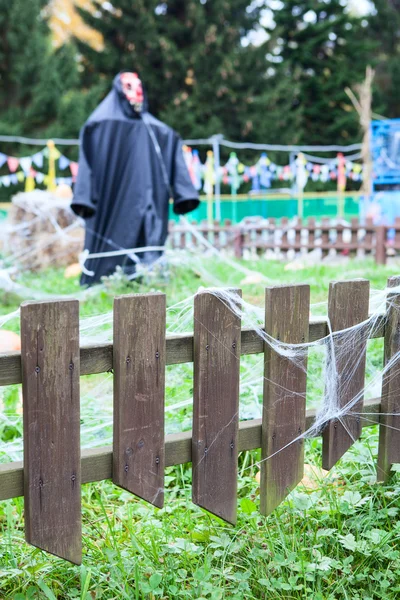 Пугало в черном пальто стоит посреди сада — стоковое фото