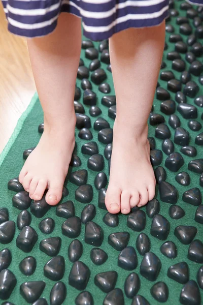 Children little feet standing on massage mat for flatfoot therapy — Stock Photo, Image