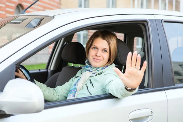 Blond hair greeting by hand from car window — Stock Photo, Image