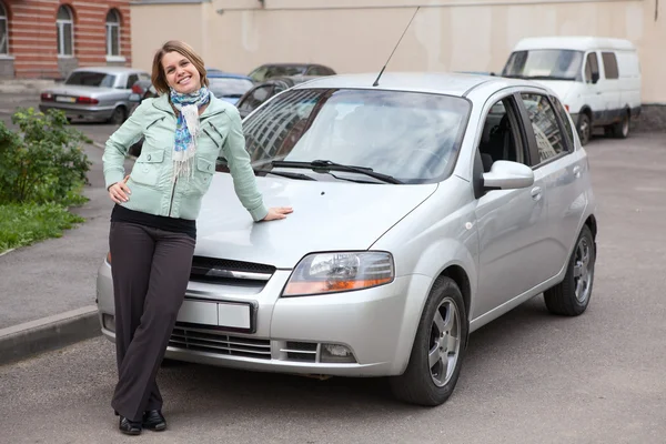 Szczęśliwą kobietą stojącą przed własnym samochodem — Zdjęcie stockowe