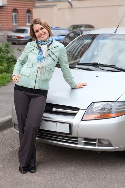 Happy beautiful woman standing in front of new car Royalty Free Stock Photos