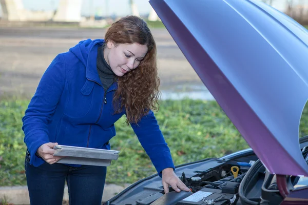 Kvinna en förare med touchpad reparera trasiga bil med öppnade motorhuven — Stockfoto