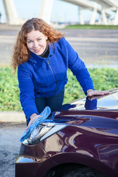 Aantrekkelijk meisje schoonmaken van haar auto — Stockfoto