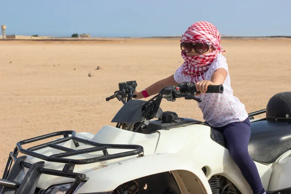 Little girl driving quad bike in desert — Stock Photo, Image