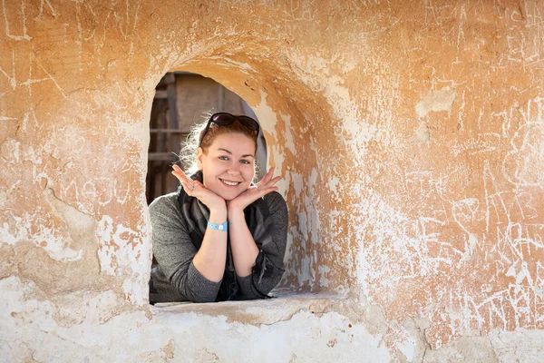 Caucasian woman in ancient wall loophole cheerful and happy — Stock Photo, Image