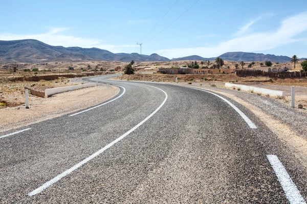 Asphalt way with white road marking in mountain terrain of Africa — Stock Photo, Image