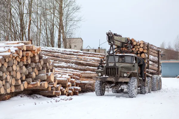 Log loader track with timber in lumber mill in winter season — Stock Photo, Image