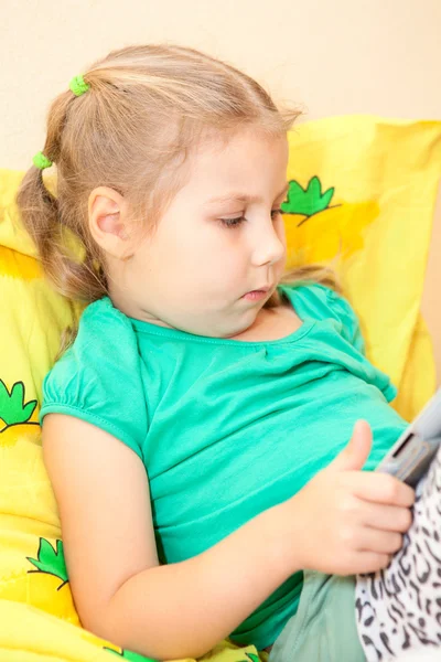 Pequena criança caucasiana com tablet digital pc na cama — Fotografia de Stock