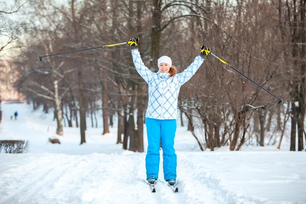 Vrouw sportman op grensoverschrijdende ski met handen omhoog — Stockfoto