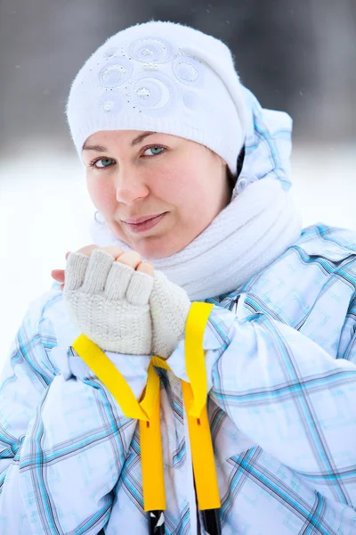 Jeune femme réchauffant les doigts avec des bâtons de ski dans les mains — Photo