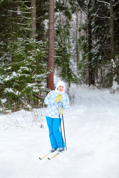 Glada unga skidåkare med skidstavar i händer upp i vinter skog — Stockfoto