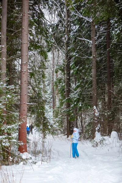 Kayak derin kış orman içinde duran mutlu genç kadın