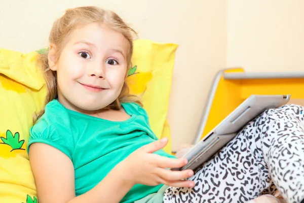 Little Caucasian child with digital tablet pc on bed — Stock Photo, Image