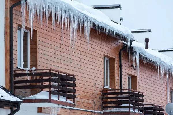 Evin çatı balkon üzerinde overhanging buz sarkıtları — Stok fotoğraf