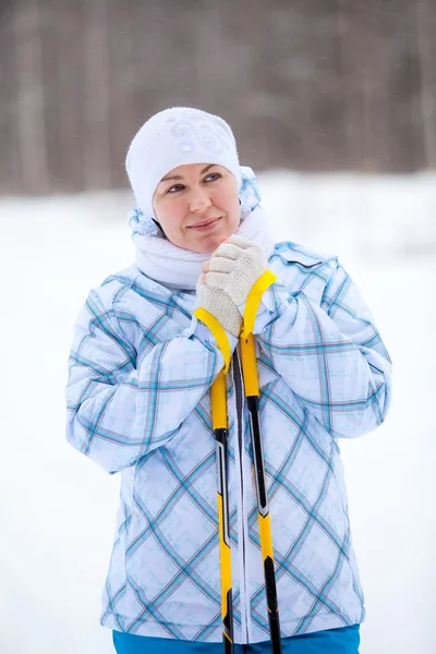 Beauty Caucasian woman warming frozen hands with ski poles in winter — Stock Photo, Image