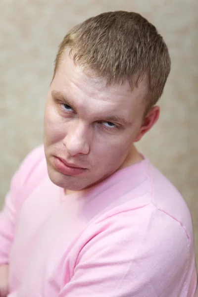 Porträt eines gut aussehenden Mannes mit blonden Haaren, der in rosa Kleidung in die Kamera lächelt — Stockfoto