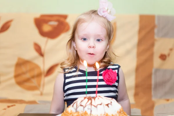 Niña caucásica soplar dos velas en el pastel de cumpleaños — Foto de Stock