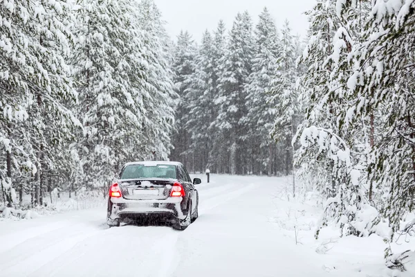 Černá země vozidla stojícího na venkovské silnici v zimním lese Severní — Stock fotografie