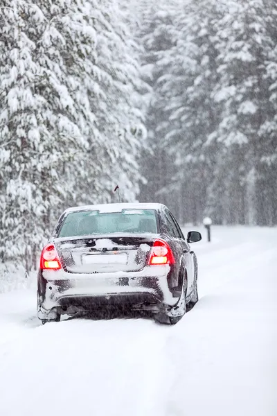 Zwarte auto staande op een landweg in winterse noordelijke bos — Stockfoto