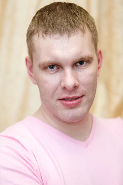 Close-up van Kaukasische knap blond haar man in roze t-shirt — Stockfoto