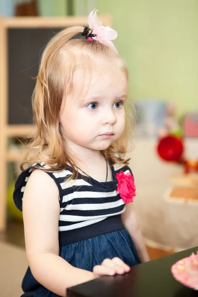 Cute young child sitting at the table in domestic room — Stock Photo, Image