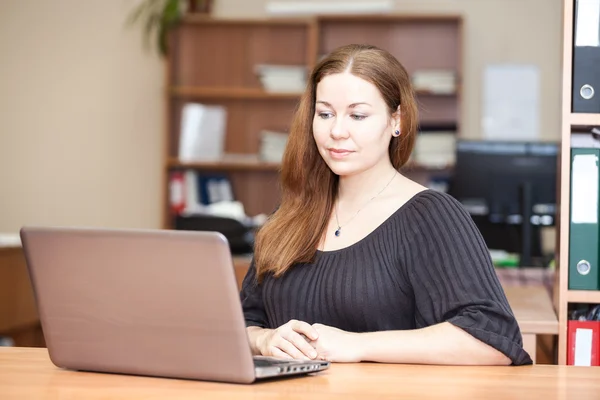 Kobieta piękna brunetka pracy z laptopem w biurze — Zdjęcie stockowe