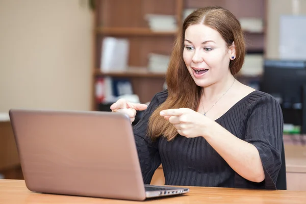 사무실에서 노트북 화면에서 가리키는 감정적 성공적인 여자 — 스톡 사진