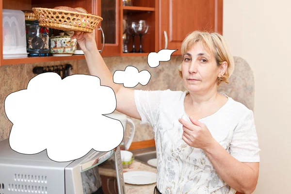 Senior woman with bread in domestic kitchen — Stock Photo, Image