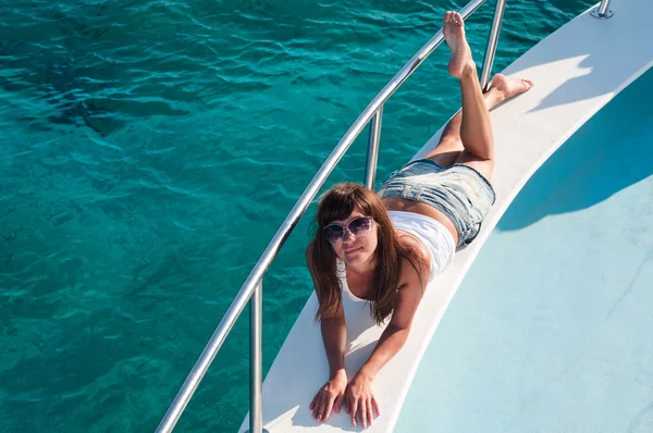 Girl tanning on deck of a yacht — Stock Photo, Image