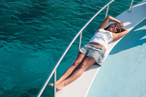 Женщина в солнцезащитных очках лежит на яхте — стоковое фото