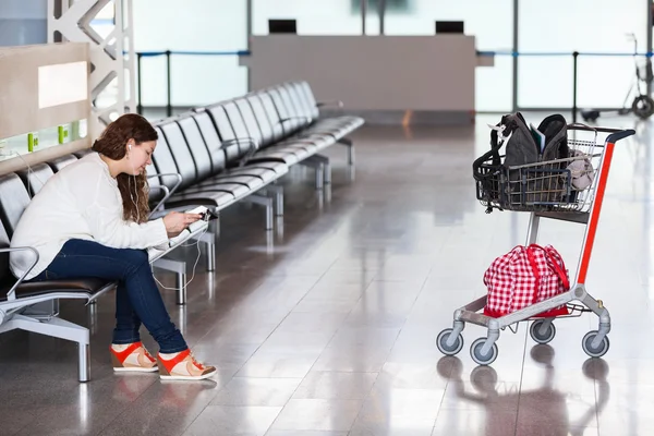 Tijd doorbrengen in luchthaven lounge met bagage hand-cart — Stockfoto