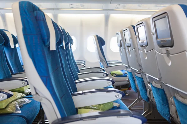 Empty comfortable seats in cabin of huge aircraft with screens in chairs back — Stock Photo, Image