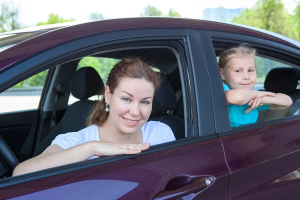 Mère de Caucasiens et jeune fille regardant la caméra de vitres de voiture — Photo