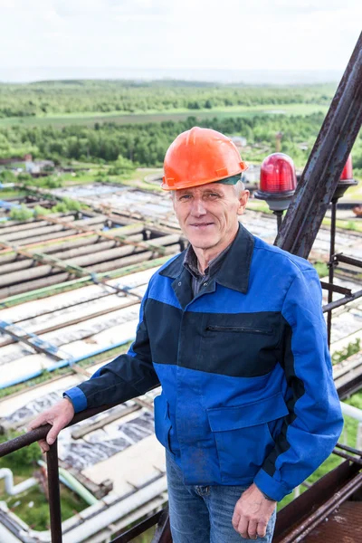 Sorrindo caucasiano trabalhador sênior permanente para plataforma de alta altitude. — Fotografia de Stock