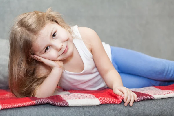 Bonita niña caucásica tumbada en el sofá — Foto de Stock