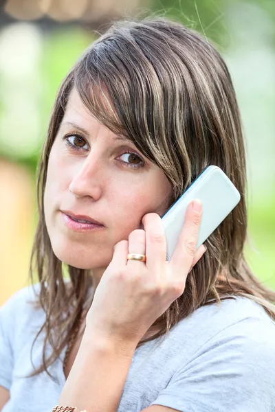 Mulher jovem caucasiana falando no telefone celular ao ar livre — Fotografia de Stock