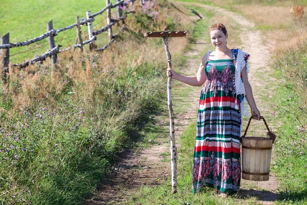 Landfrau steht mit Harken — Stockfoto