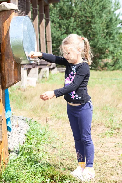 Menina lavar a mão no dispensador de água ao ar livre — Fotografia de Stock